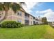 View of the exterior of a townhouse-style home with lawn and landscaping at 5240 Hyland Hills Ave # 1426, Sarasota, FL 34241