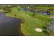 Beautiful golf course with lakeside view surrounded by tropical trees and well-manicured green at 5240 Hyland Hills Ave # 1426, Sarasota, FL 34241