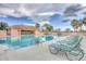 Sparkling swimming pool with lounge chairs and covered seating area, surrounded by lush landscaping and palm trees at 5240 Hyland Hills Ave # 1426, Sarasota, FL 34241