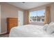A cozy bedroom features a window providing natural light, neutral colored walls and hardwood style floors at 5512 Riverbluff Cir # V-16, Sarasota, FL 34231