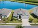 An aerial view showcases a well-maintained house with manicured landscaping near a serene lake at 5744 Woodland Sage Dr, Sarasota, FL 34238