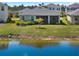 A serene backyard view featuring a screened lanai, lush landscaping, and a tranquil pond at 5744 Woodland Sage Dr, Sarasota, FL 34238