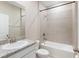 A bright bathroom features a white sink, granite countertop, white cabinets, and tiled shower-bath combination at 5744 Woodland Sage Dr, Sarasota, FL 34238