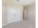 Neutral bedroom featuring carpet flooring, white trim, double door closet, and an adjacent room at 5744 Woodland Sage Dr, Sarasota, FL 34238