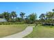 Well-manicured community green space featuring a walking path, seating, and lush tropical landscape at 5744 Woodland Sage Dr, Sarasota, FL 34238