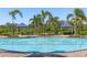 Resort-style community pool with shade structures, lush landscaping, and comfortable seating at 5744 Woodland Sage Dr, Sarasota, FL 34238