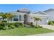 Well-kept one-story home with a two-car garage and tropical landscaping on a sunny day at 5744 Woodland Sage Dr, Sarasota, FL 34238