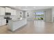 Open-concept kitchen with a central island, modern appliances, and adjacent living space with lake view at 5744 Woodland Sage Dr, Sarasota, FL 34238