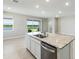 Modern kitchen island features a stainless steel dishwasher, granite counters and overlooks a serene lake at 5744 Woodland Sage Dr, Sarasota, FL 34238