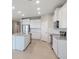 A bright, modern kitchen with white cabinets, granite countertops, stainless steel appliances, and tile floors at 5744 Woodland Sage Dr, Sarasota, FL 34238
