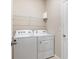 A laundry room features a side-by-side washer and dryer, and a wire shelf at 5744 Woodland Sage Dr, Sarasota, FL 34238