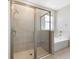 Bathroom with glass shower, white tub, chrome hardware, and neutral-toned tiles at 5744 Woodland Sage Dr, Sarasota, FL 34238