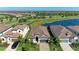 Scenic aerial view of a home with a tile roof and a paver driveway in a community with ponds and a golf course at 5817 Brandon Run, Bradenton, FL 34211