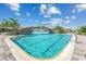 Serene community pool highlighted by a rock waterfall feature and clear, inviting water, set under a sunny sky with scattered clouds at 5817 Brandon Run, Bradenton, FL 34211