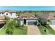 Beautiful home with a well-manicured lawn, brick driveway, and tropical landscaping, located on a golf course at 5817 Brandon Run, Bradenton, FL 34211