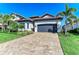 Well-maintained single-Gathering home with a paver driveway, a two-car garage, and mature palm trees at 5817 Brandon Run, Bradenton, FL 34211