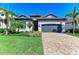 Charming single-story home featuring lush landscaping, a paver driveway, and a two-car garage at 5817 Brandon Run, Bradenton, FL 34211
