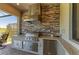 Outdoor kitchen boasts a built-in grill, stone backsplash, and granite countertops for stylish outdoor cooking at 5817 Brandon Run, Bradenton, FL 34211