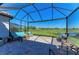 Screened-in patio offering comfortable lounge chairs and a view of the tranquil lake and lush green landscape at 5817 Brandon Run, Bradenton, FL 34211