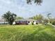 Expansive backyard featuring lush lawn, tropical trees and plants and screened-in patio at 5906 Garden Lakes Majestic, Bradenton, FL 34203