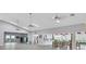 Large clubhouse interior with stainless steel refrigerator, dining area and gray plank floors at 5906 Garden Lakes Majestic, Bradenton, FL 34203