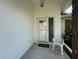 Inviting front entryway featuring a white door with glass accents, a decorative chair, and neutral concrete at 5906 Garden Lakes Majestic, Bradenton, FL 34203