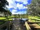 Scenic lake view from a wooden deck with table and chairs, ideal for relaxation and enjoying the outdoors at 5906 Garden Lakes Majestic, Bradenton, FL 34203