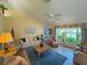Bright living room featuring vaulted ceilings, neutral colors, ceiling fan, and a large window at 5906 Garden Lakes Majestic, Bradenton, FL 34203