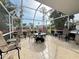 Screened patio with tiled flooring features an outdoor dining set and a seating arrangement at 5906 Garden Lakes Majestic, Bradenton, FL 34203