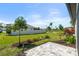 Expansive backyard featuring a stone patio, lush lawn, tasteful landscaping, and privacy fence at 5998 Amberly Dr, Bradenton, FL 34208