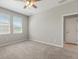 A bright bedroom with neutral walls, trim, and carpet with two windows for natural light at 5998 Amberly Dr, Bradenton, FL 34208