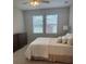 Neutral bedroom features a ceiling fan, carpet floors, a dresser, and a comfortable bed with a white comforter at 5998 Amberly Dr, Bradenton, FL 34208