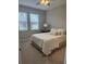 Neutral bedroom with a ceiling fan, windows, carpet floors, and a comfortable bed with a white comforter at 5998 Amberly Dr, Bradenton, FL 34208