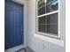 Stylish blue front door with a secure lock and handle set, complemented by a bright window and exterior paint at 5998 Amberly Dr, Bradenton, FL 34208
