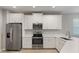 Modern kitchen featuring stainless steel appliances, white cabinetry, quartz countertops, and tile flooring at 5998 Amberly Dr, Bradenton, FL 34208