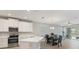 Open-concept kitchen with stainless steel appliances, sleek white cabinetry, and quartz countertops at 5998 Amberly Dr, Bradenton, FL 34208