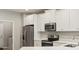 Modern kitchen featuring stainless steel appliances, white cabinetry, and sleek countertops, perfect for cooking at 5998 Amberly Dr, Bradenton, FL 34208