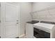 Neat laundry room featuring a white washer and dryer, a white door, and wire shelving at 5998 Amberly Dr, Bradenton, FL 34208
