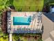 Aerial view of a rectangular swimming pool with surrounding lounge chairs and manicured landscaping at 5998 Amberly Dr, Bradenton, FL 34208