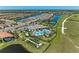 Aerial view of a community clubhouse featuring a pool, spa, tennis courts, and bocce ball, surrounded by manicured landscaping at 6179 Mesa Gln, Bradenton, FL 34203