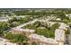 Aerial view of the condo community with trees, buildings, and a central pond at 625 30Th W Ave # G308, Bradenton, FL 34205