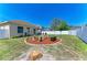 Backyard with fire pit and seating in a landscaped area at 6415 Fetterbush Ln, Lakewood Ranch, FL 34202