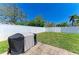 Spacious backyard featuring a well-maintained lawn, stone pavers, and a covered outdoor grill at 6415 Fetterbush Ln, Lakewood Ranch, FL 34202
