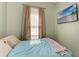 Cozy bedroom features neutral tones, natural light, and a mounted television for relaxing comfort at 6415 Fetterbush Ln, Lakewood Ranch, FL 34202