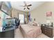 Bedroom with ceiling fan, desk, TV, window, and light colored walls at 6415 Fetterbush Ln, Lakewood Ranch, FL 34202