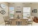 Bright dining room featuring a rustic table set, neutral walls, and multiple large windows at 6415 Fetterbush Ln, Lakewood Ranch, FL 34202