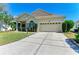 Well-maintained home with lush front lawn, manicured bushes, and a wide driveway leading to the garage at 6415 Fetterbush Ln, Lakewood Ranch, FL 34202