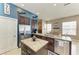 Kitchen showcasing dark cabinets, granite countertops, stainless steel appliances, tile floors, and island with sink at 6415 Fetterbush Ln, Lakewood Ranch, FL 34202