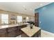 A spacious kitchen and dining area shows granite counters, dark cabinets, and an island with sink at 6415 Fetterbush Ln, Lakewood Ranch, FL 34202