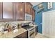 Close up of the kitchen with dark cabinets, granite countertops, stainless steel stove, and mosaic tile backsplash at 6415 Fetterbush Ln, Lakewood Ranch, FL 34202